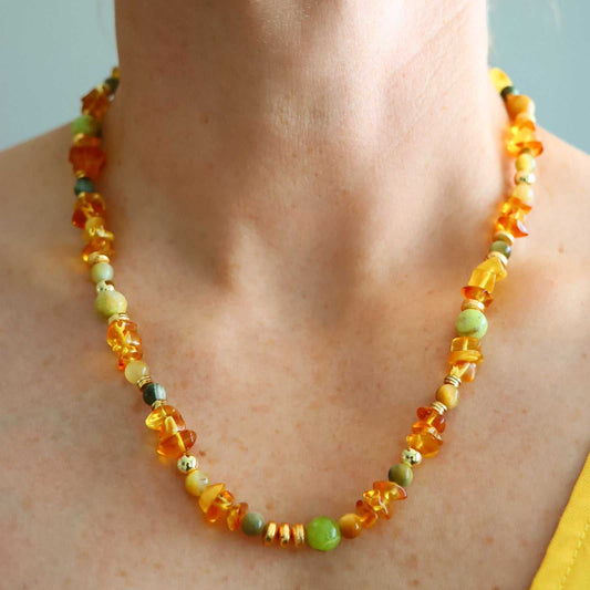 Handmade lemon Baltic amber necklace with green opal and gold beads, worn on neck
