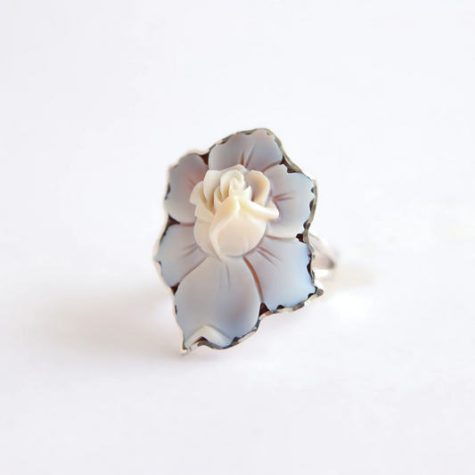 Flower ring with a white flower and gray petals on a light background