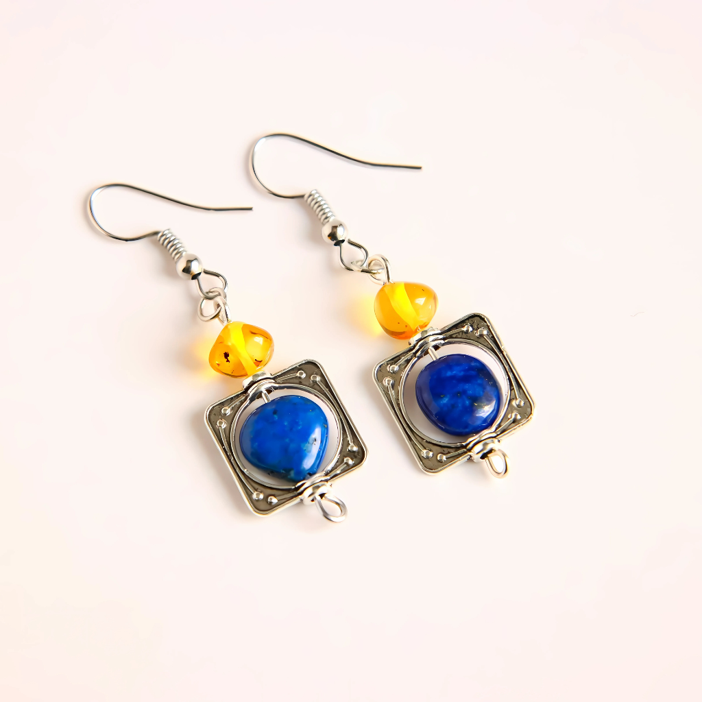 Pair of lapis earrings with blue and yellow beads on a white background