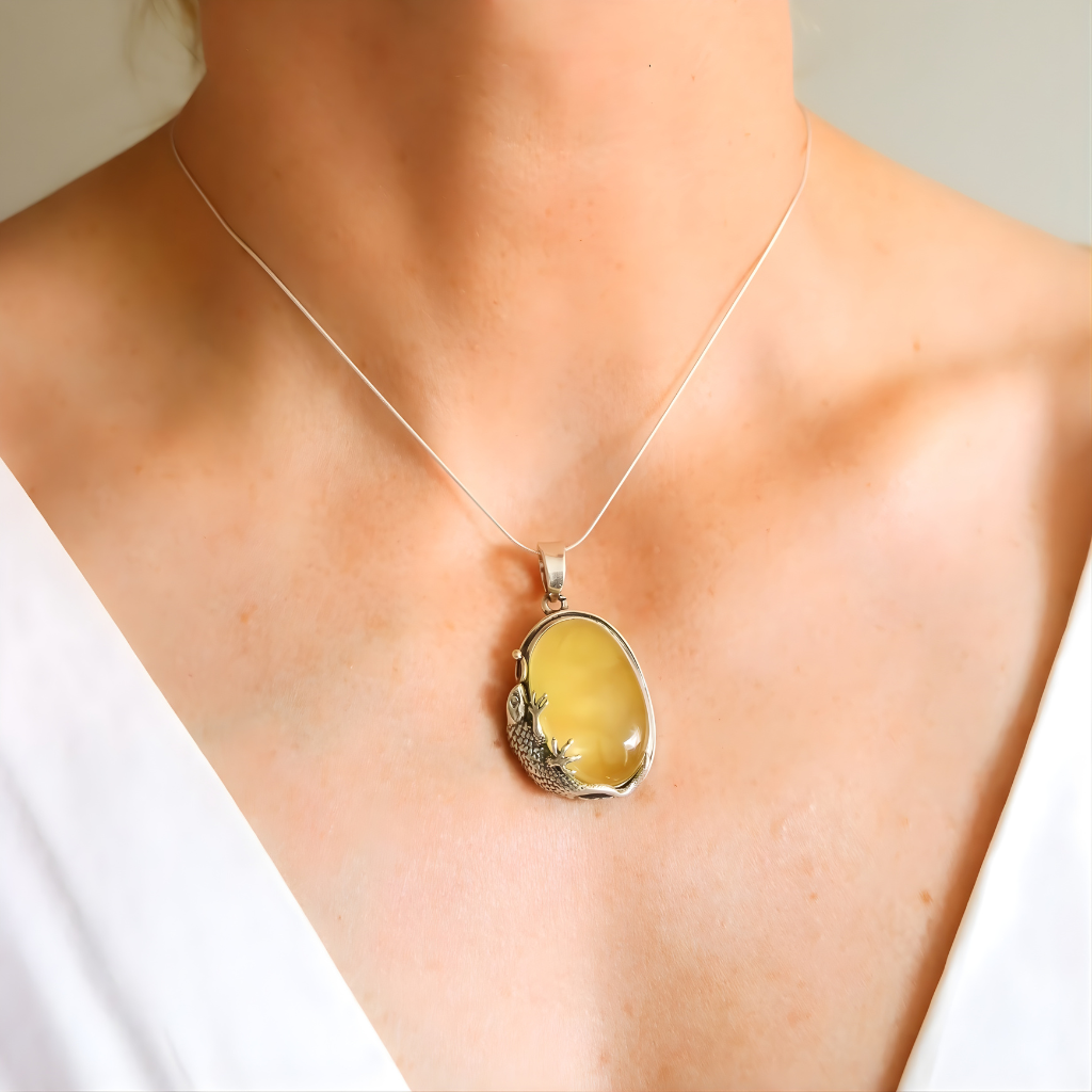 Yellow pendant amber necklace on a person wearing a white top