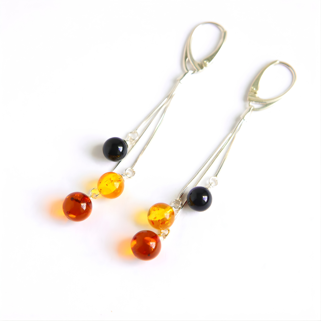 Pair of amber earrings with amber and black beads on a white background
