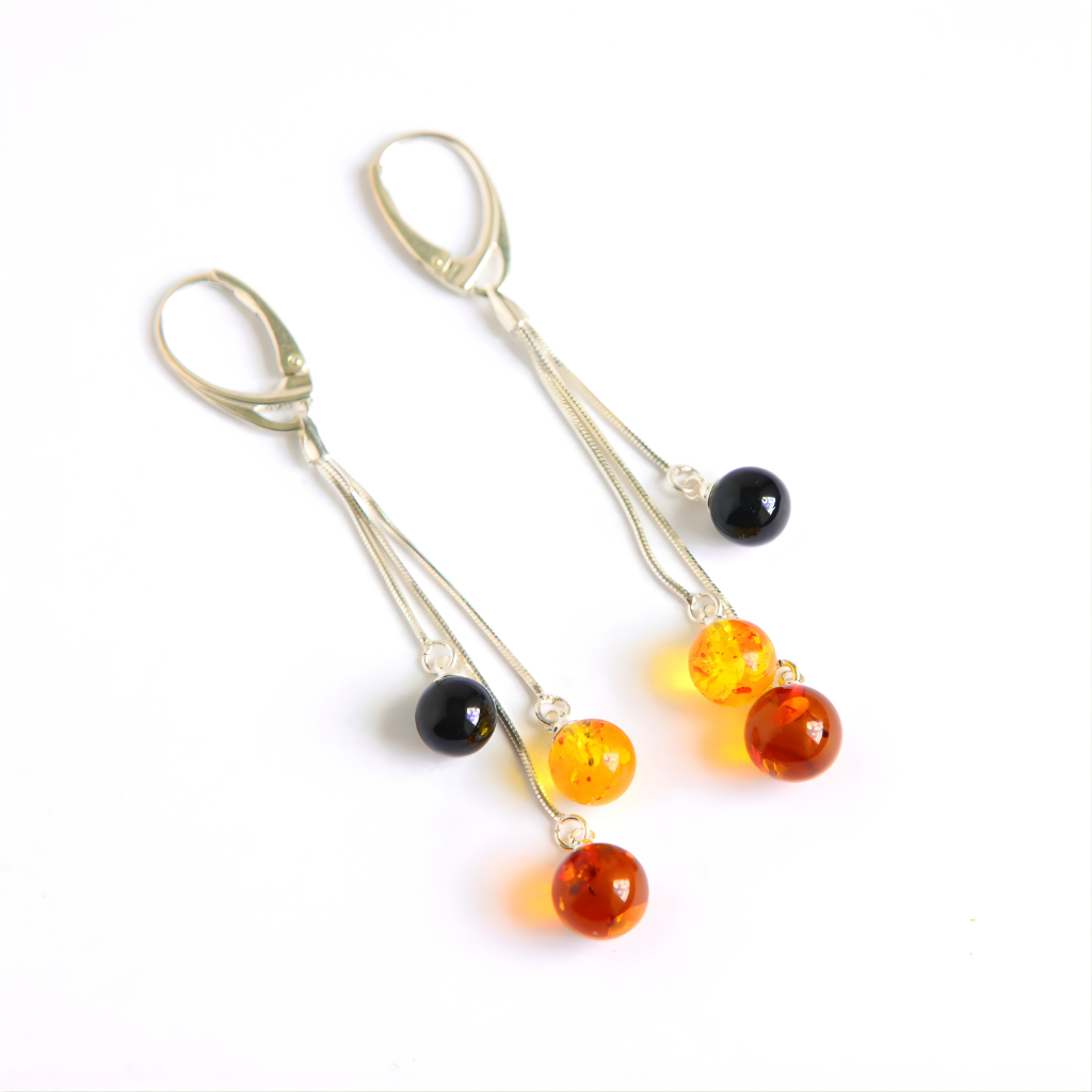 Pair of amber earrings with amber and black beads on a white background