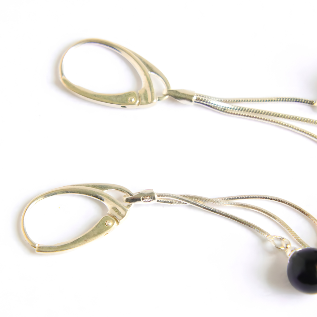 up close amber earrings showing 925 symbol on white background.
