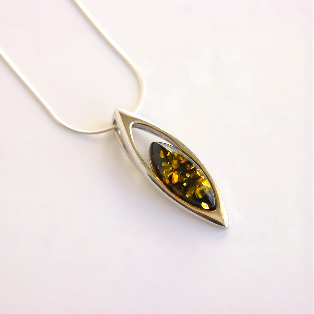 Silver amber necklace with a green gemstone on a white background
