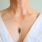 Amber Necklace with a pendant worn by a person in a white top against a neutral background