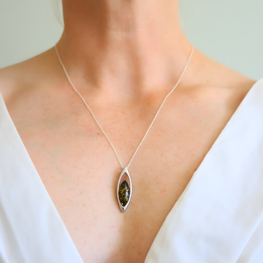 Amber Necklace with a pendant worn by a person in a white top against a neutral background