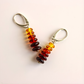 Pair of amber earrings-colored beaded earrings on a light pink background