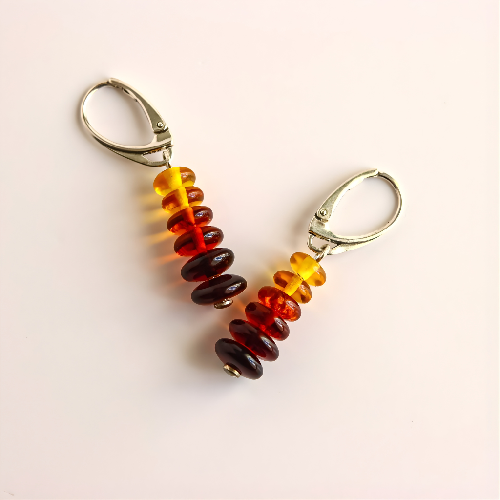 Pair of amber earrings-colored beaded earrings on a light pink background