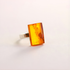 Amber Ring with a rectangular amber stone on a light gray background