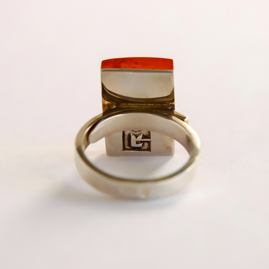 Silver amber ring with a red stone on a white background