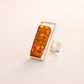 amber Ring with amber stone and silver band on a light background