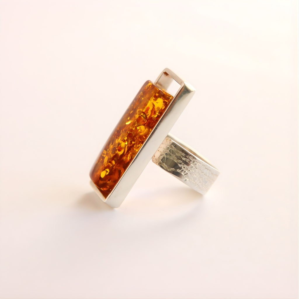 Silver amber ring with a rectangular amber stone on a light background