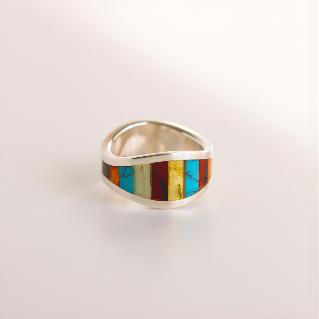 Silver amber ring with colorful inlay on a light gray background