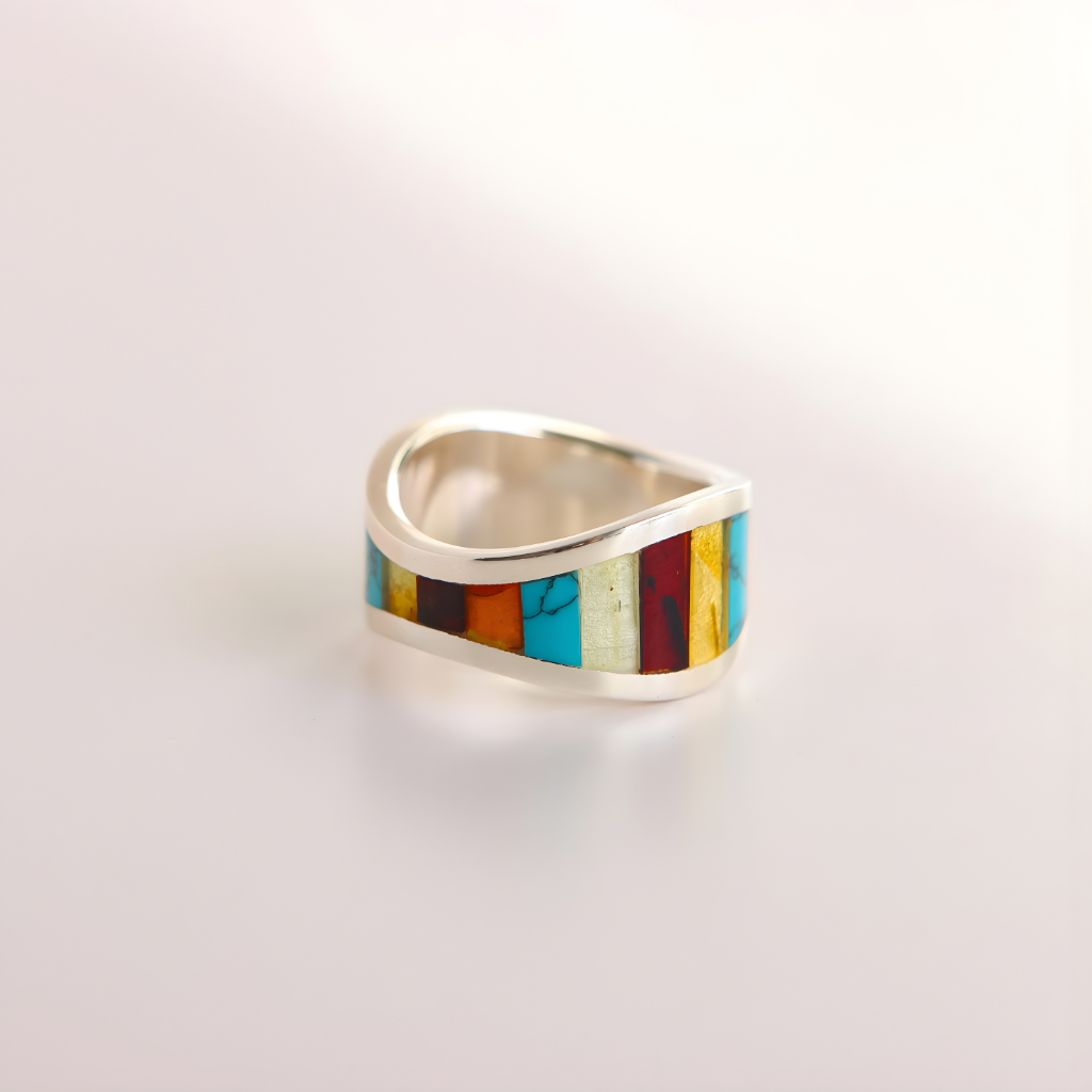 Silver amber ring with colorful inlay on a light gray background