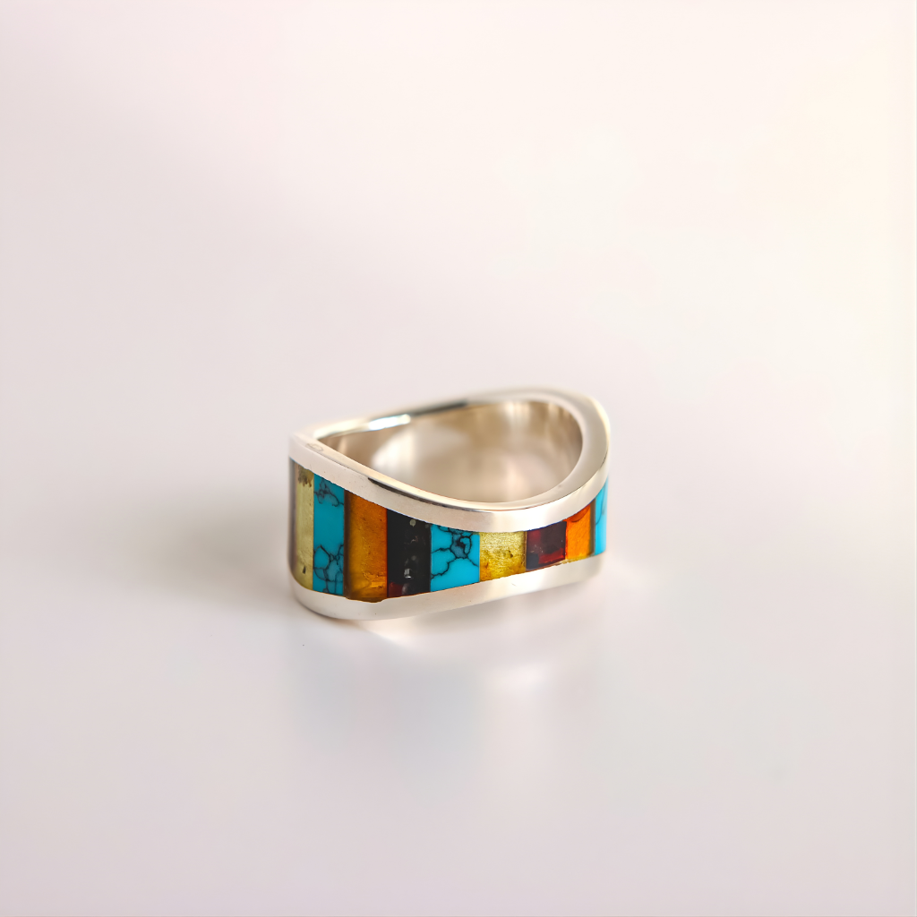 Silver amber ring with colorful inlay on a light gray background