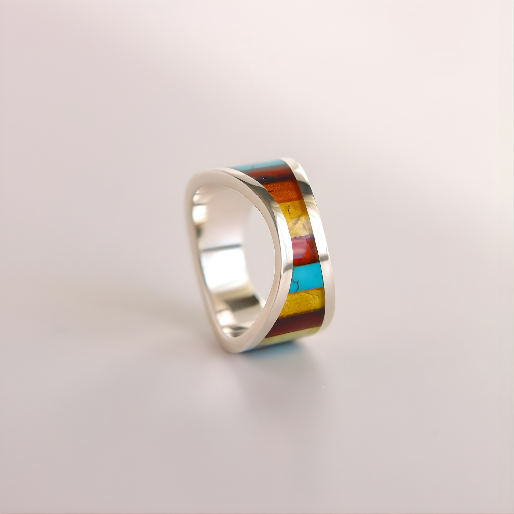 Silver amber ring with colorful inlay on a light gray background