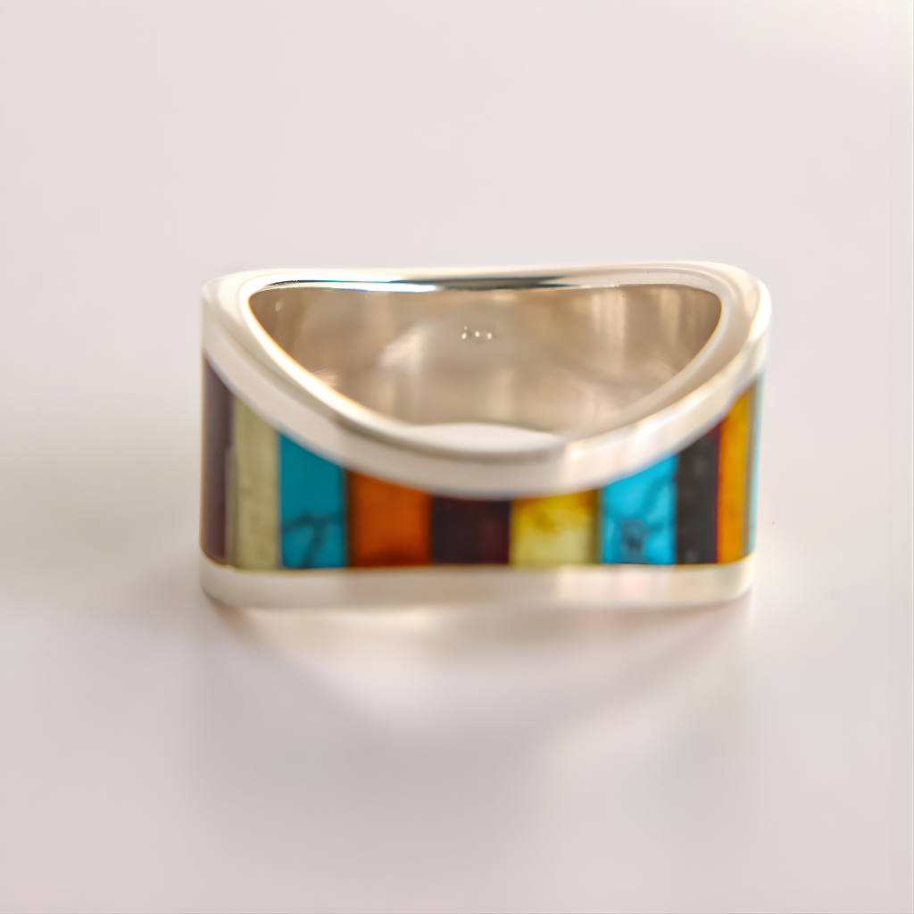 Triangular silver amber ring with colorful inlay on a light gray background