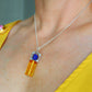 Model wearing lapis lazuli and amber pendant necklace, showcasing natural stone colors and 16-inch chain length.