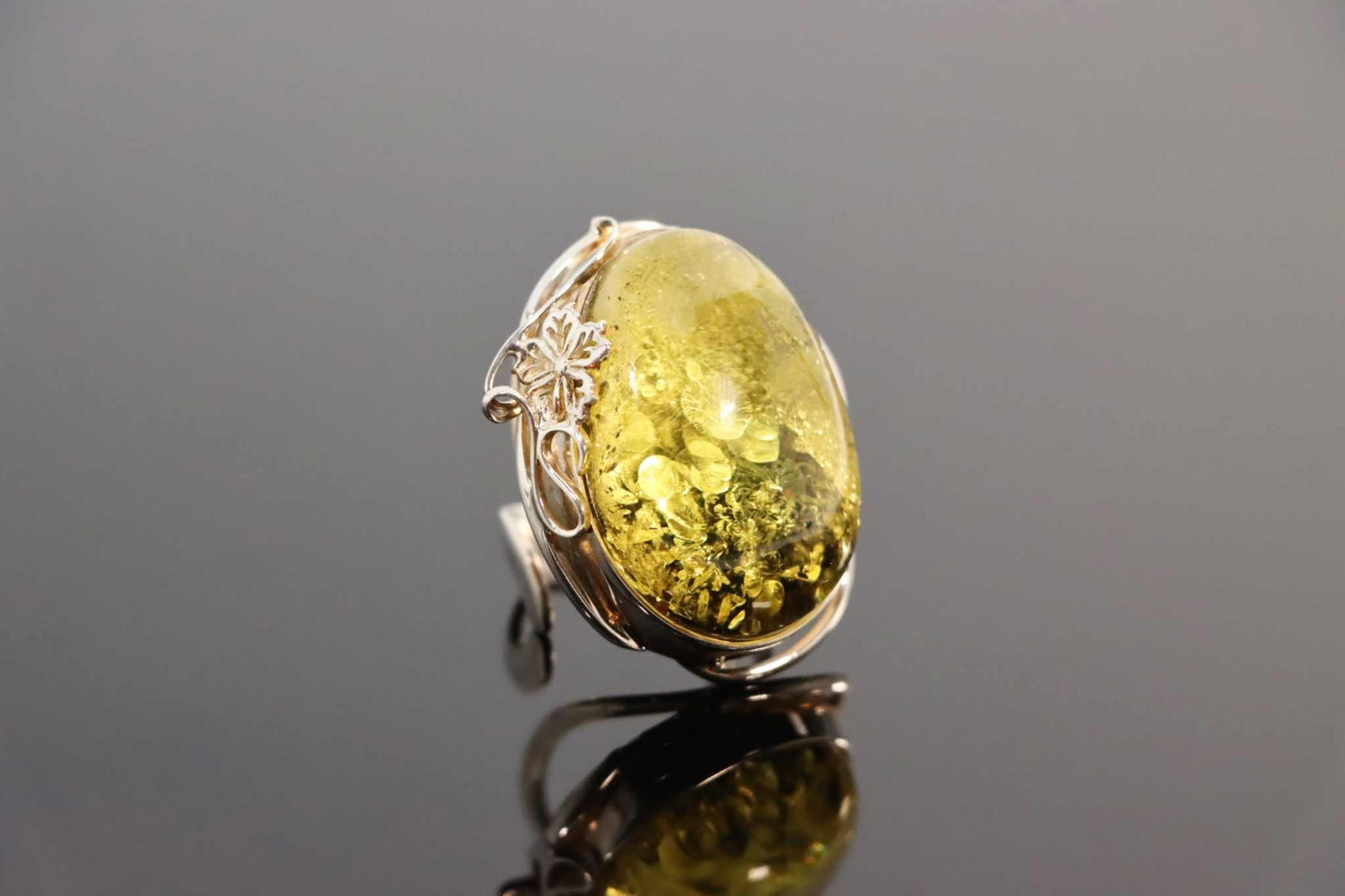 Natural Baltic green amber floral adjustable ring in 925 sterling silver with intricate design.