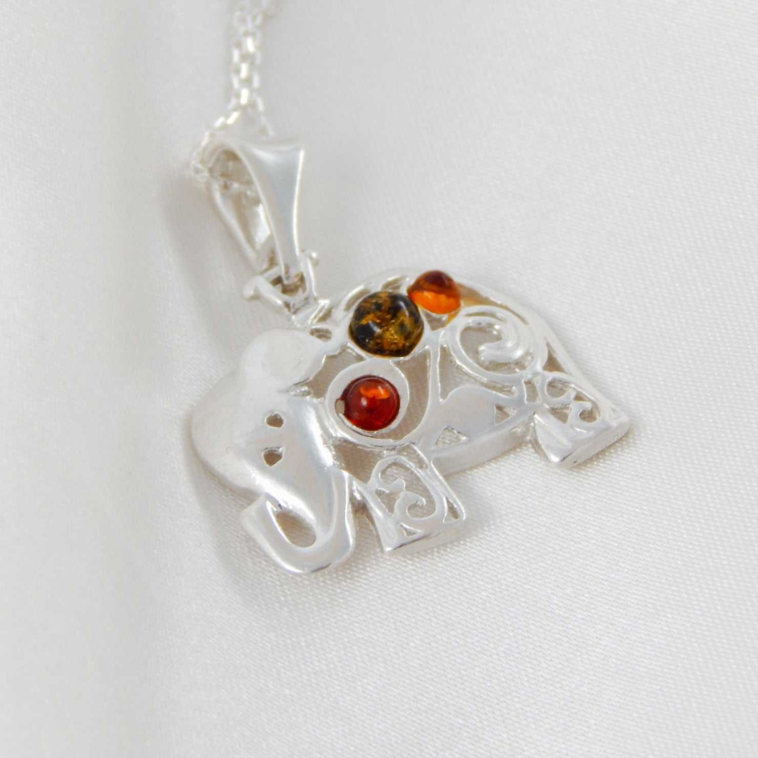 Natural Baltic multicolor amber lucky elephant pendant on sterling silver necklace.