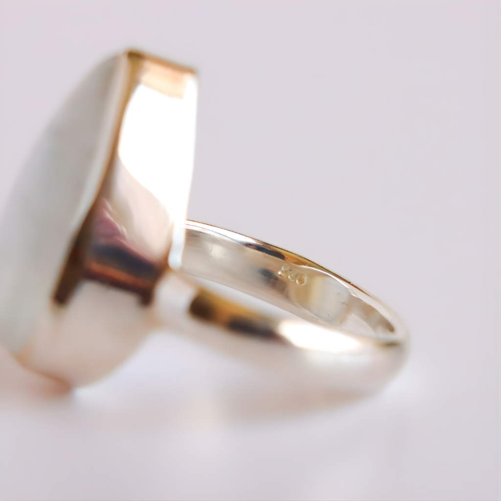 silver moonstone ring with 925 stamp on a light gray background