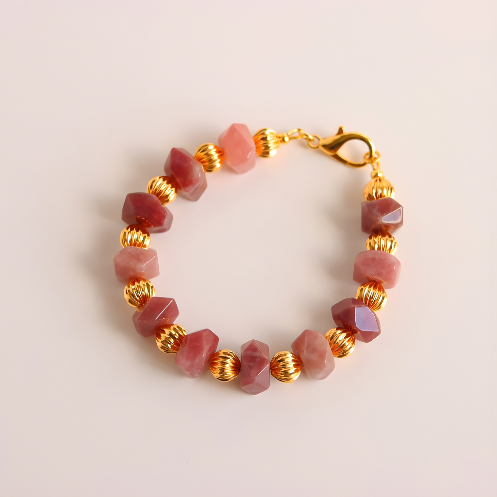 Bracelet with pink Botswana agate beads and gold accents on a light pink background
