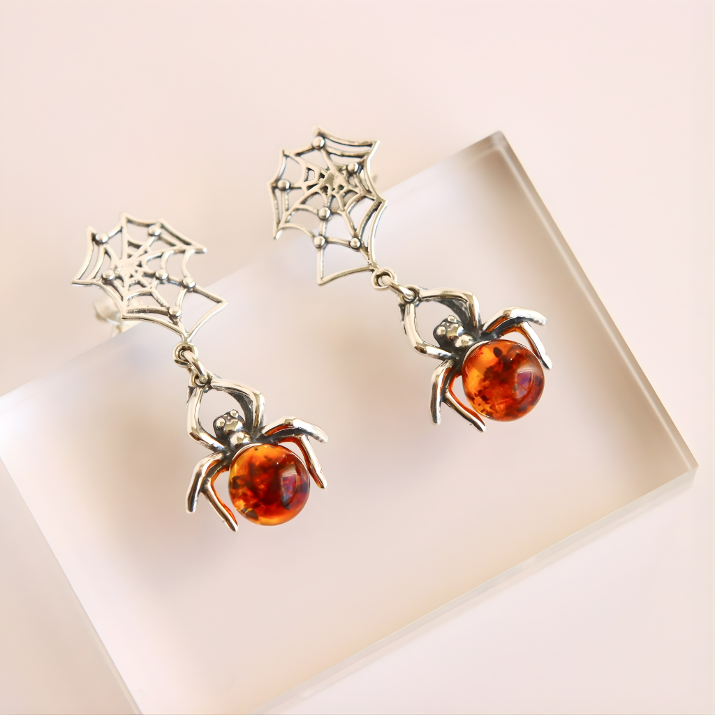 Spider amber earrings with amber stones on a white background
