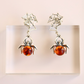 Spider amber earrings with amber stones on a light background
