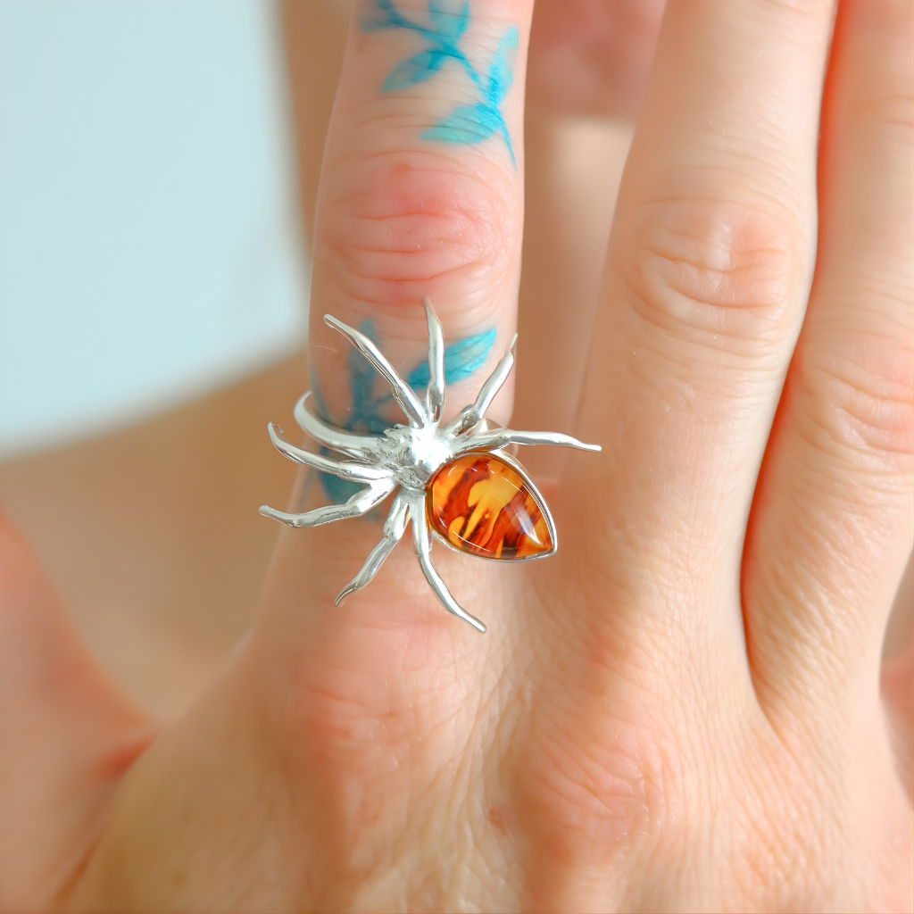 Silver spider statement ring with a amber stone on a finger