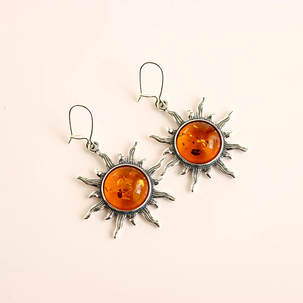sun sterling silver earrings on beige background
