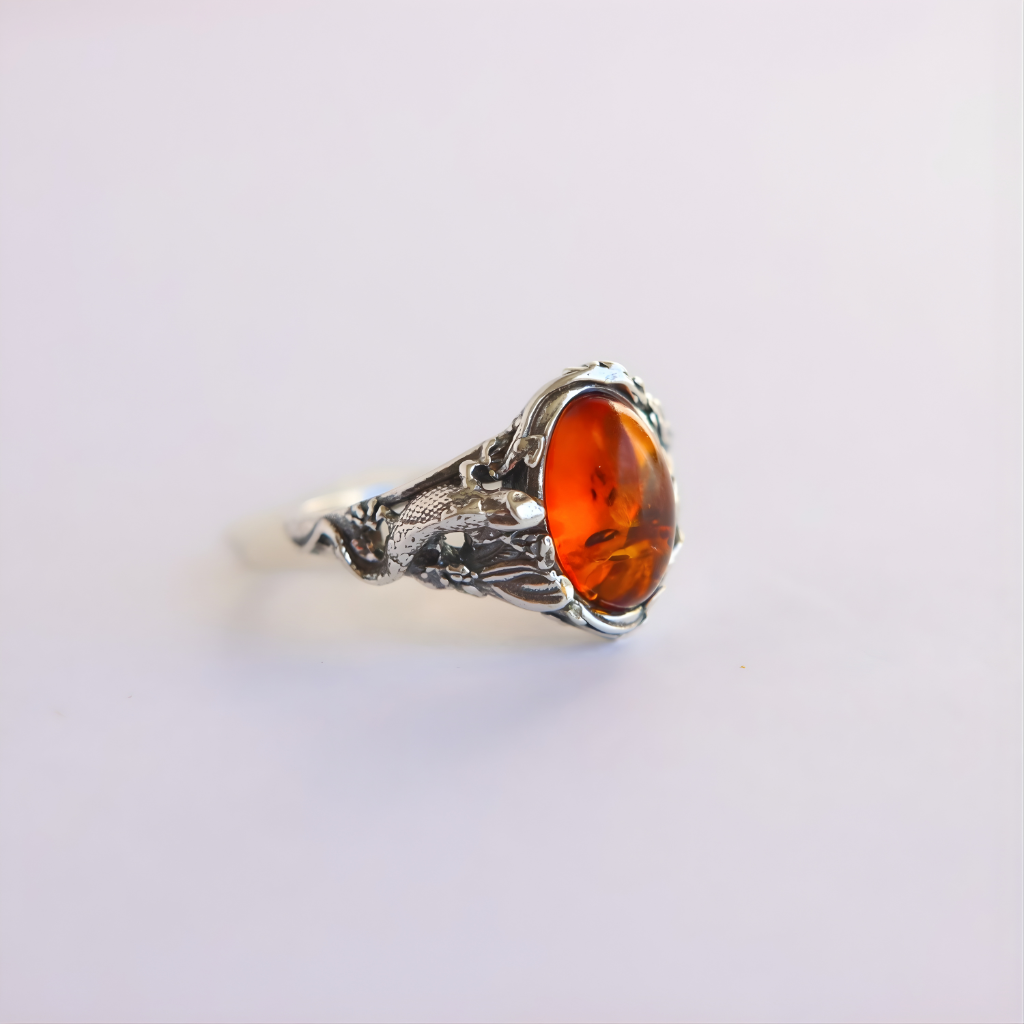 Silver amber ring with a amber stone on a light gray background