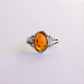 Silver amber ring with a amber stone on a light gray background