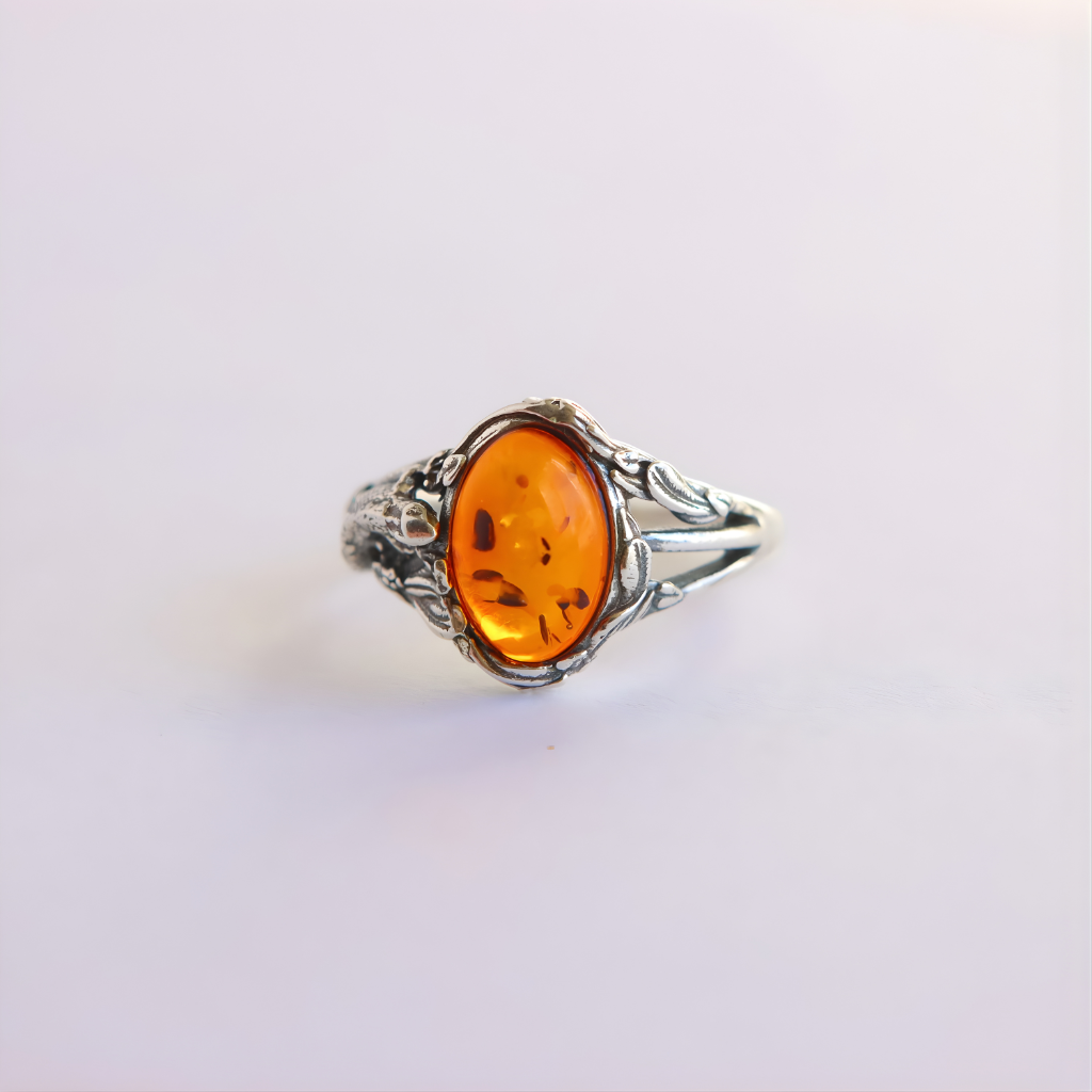 Silver amber ring with a amber stone on a light gray background