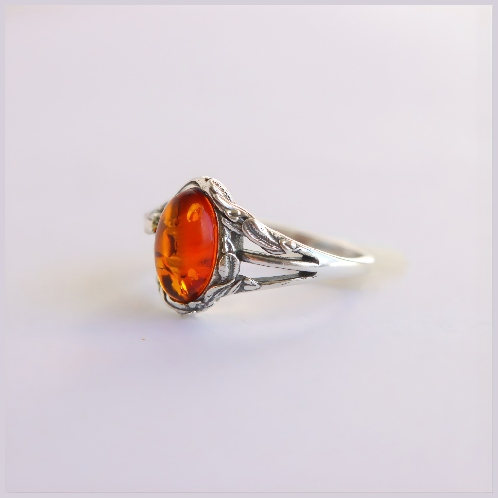 Silver amber ring with a large amber stone on a white background