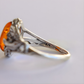 Silver amber ring with amber stone on a light gray background