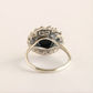Silver green amber ring with a black gemstone on a light beige background