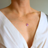 Close-up of a amethyst necklace on a person wearing a white top.