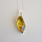 Silver pendant amber necklace with a yellow gemstone on a white background