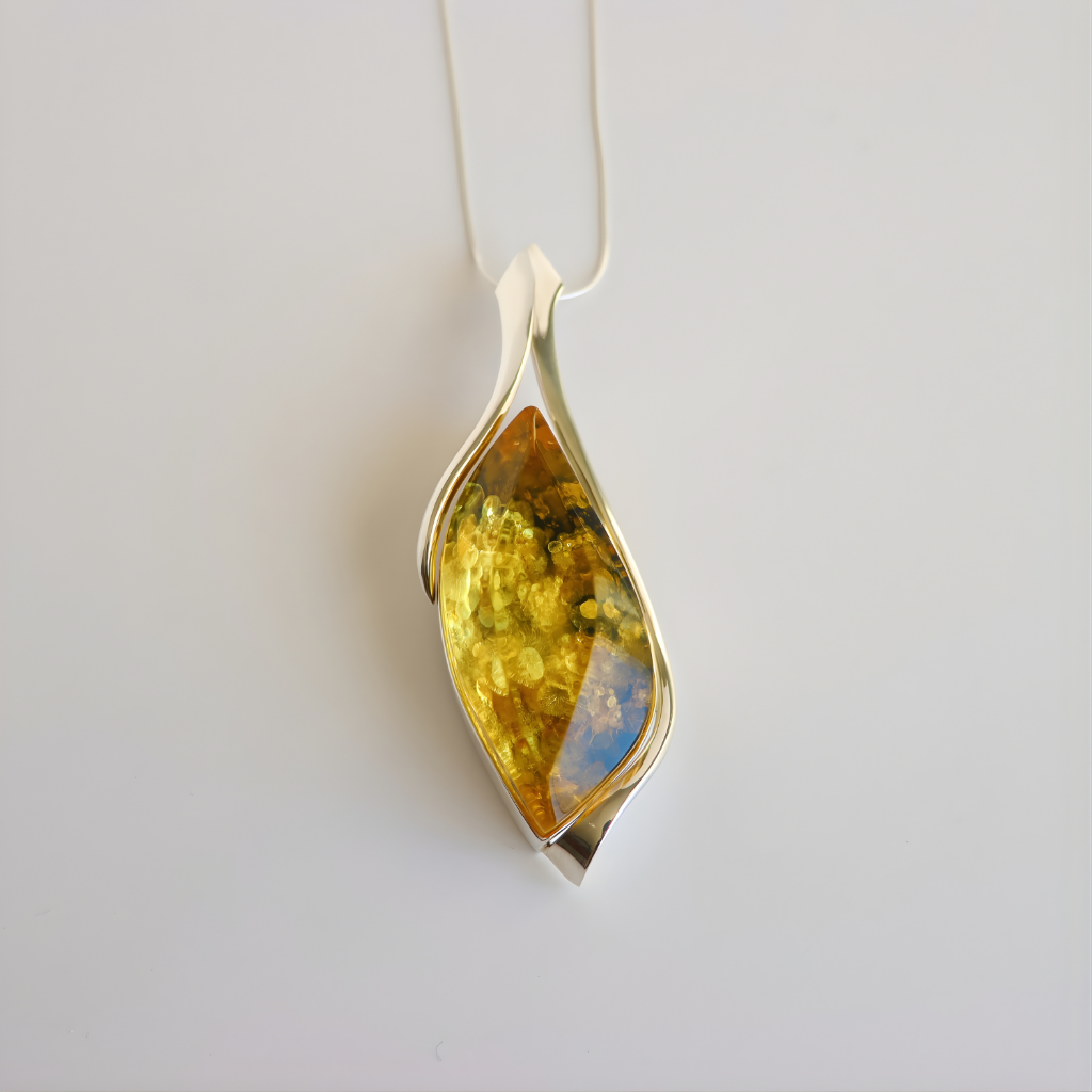 Silver pendant amber necklace with a yellow gemstone on a white background