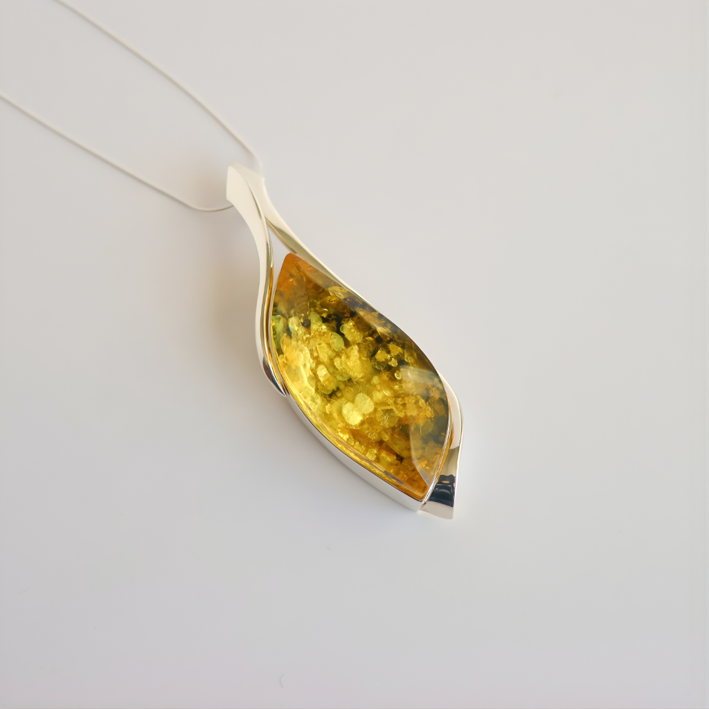 Teardrop-shaped amber pendant necklace with amber-like stone on a white background