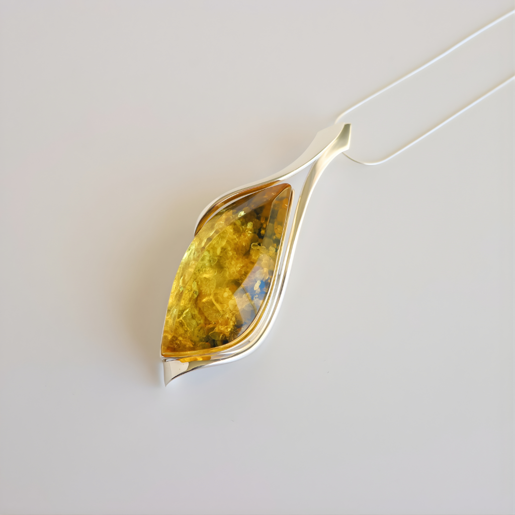 Silver amber pendant necklace with a yellow gemstone on a light gray background