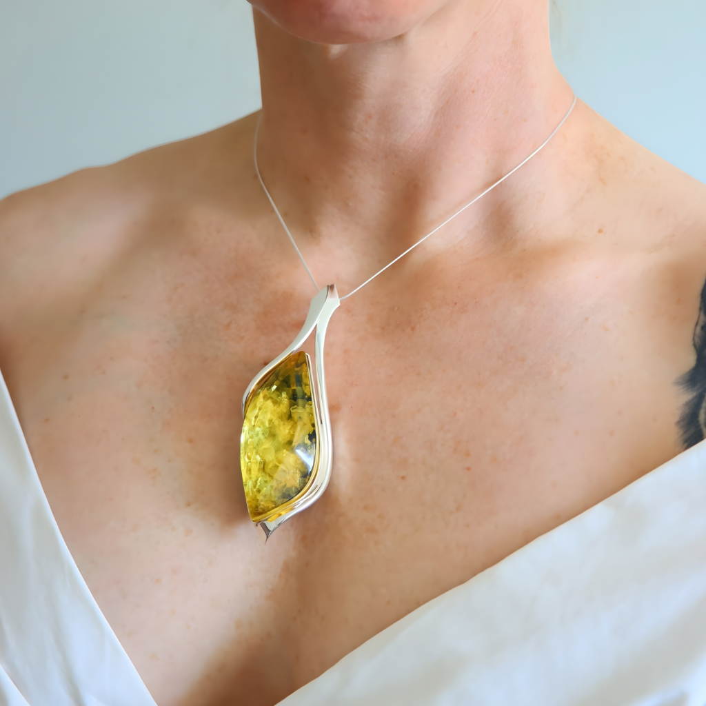 amber Necklace with a yellow pendant worn by a person against a neutral background