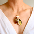 Amber Necklace with a multicolored pendant on a person wearing a white top.