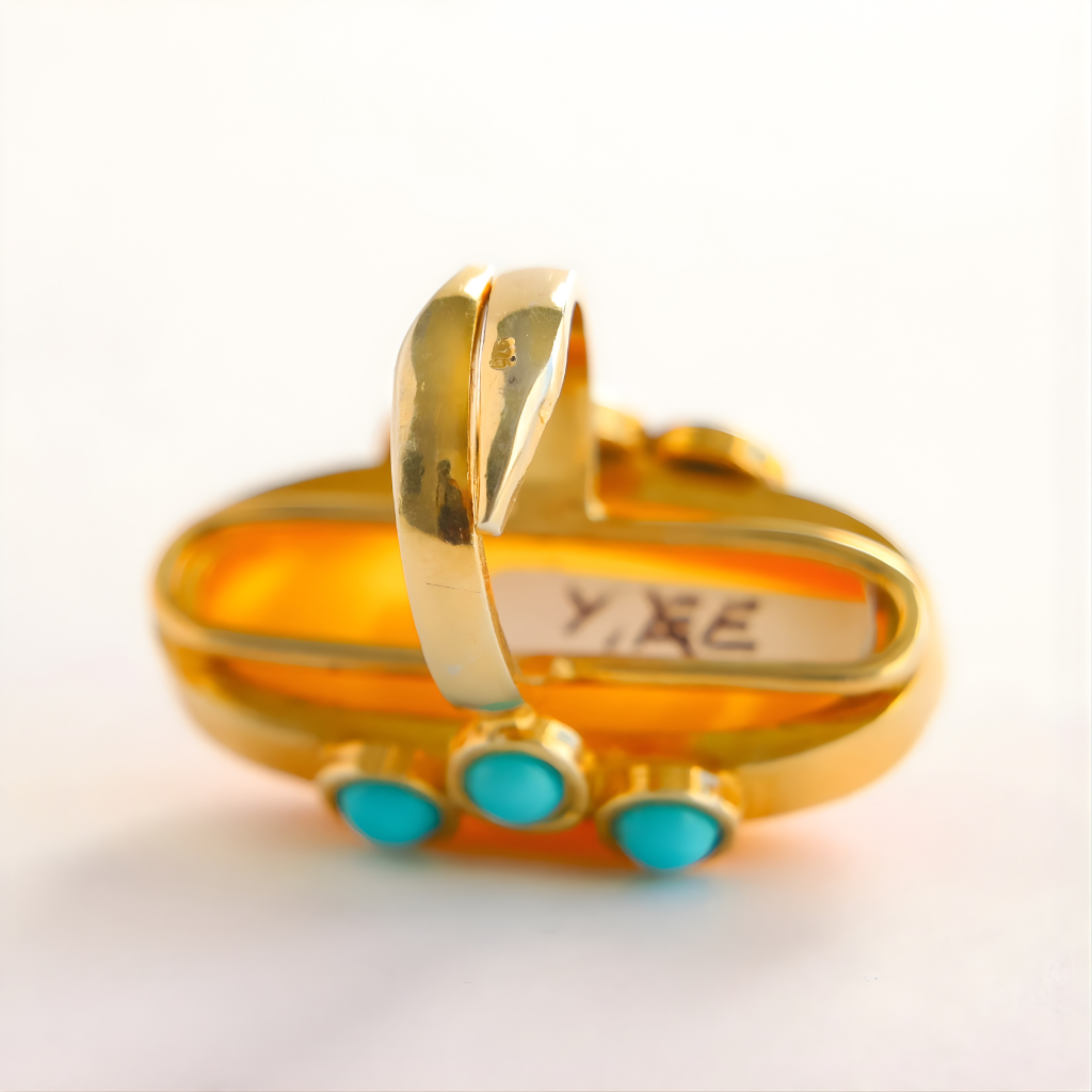 Gold amber ring with turquoise stones on a white background
