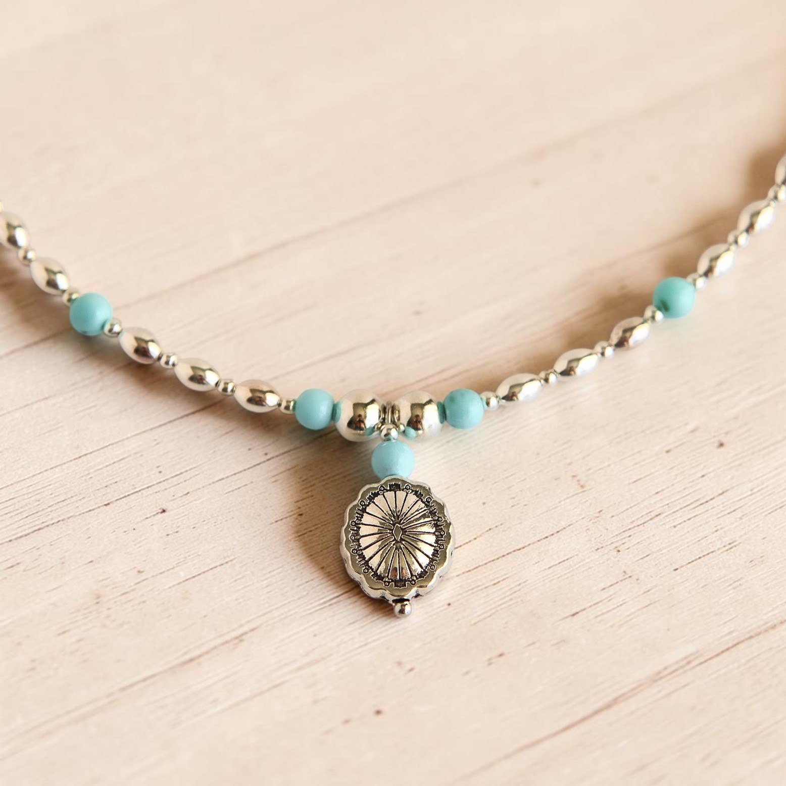 Turquoise Necklace with silver beads and pendant on white background