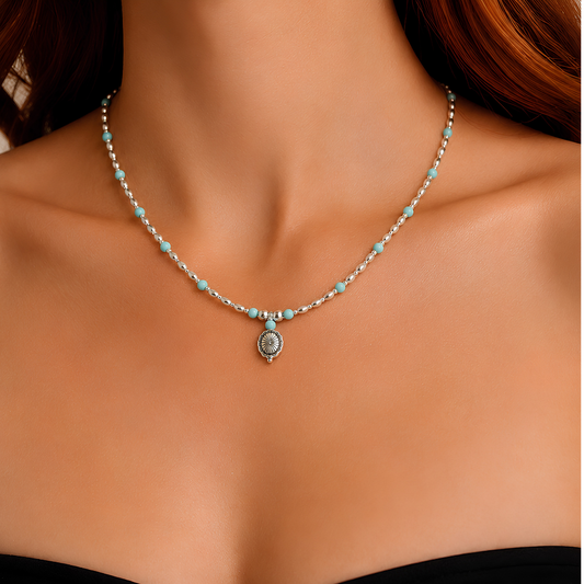 Model wearing turquoise necklace close up with red hair