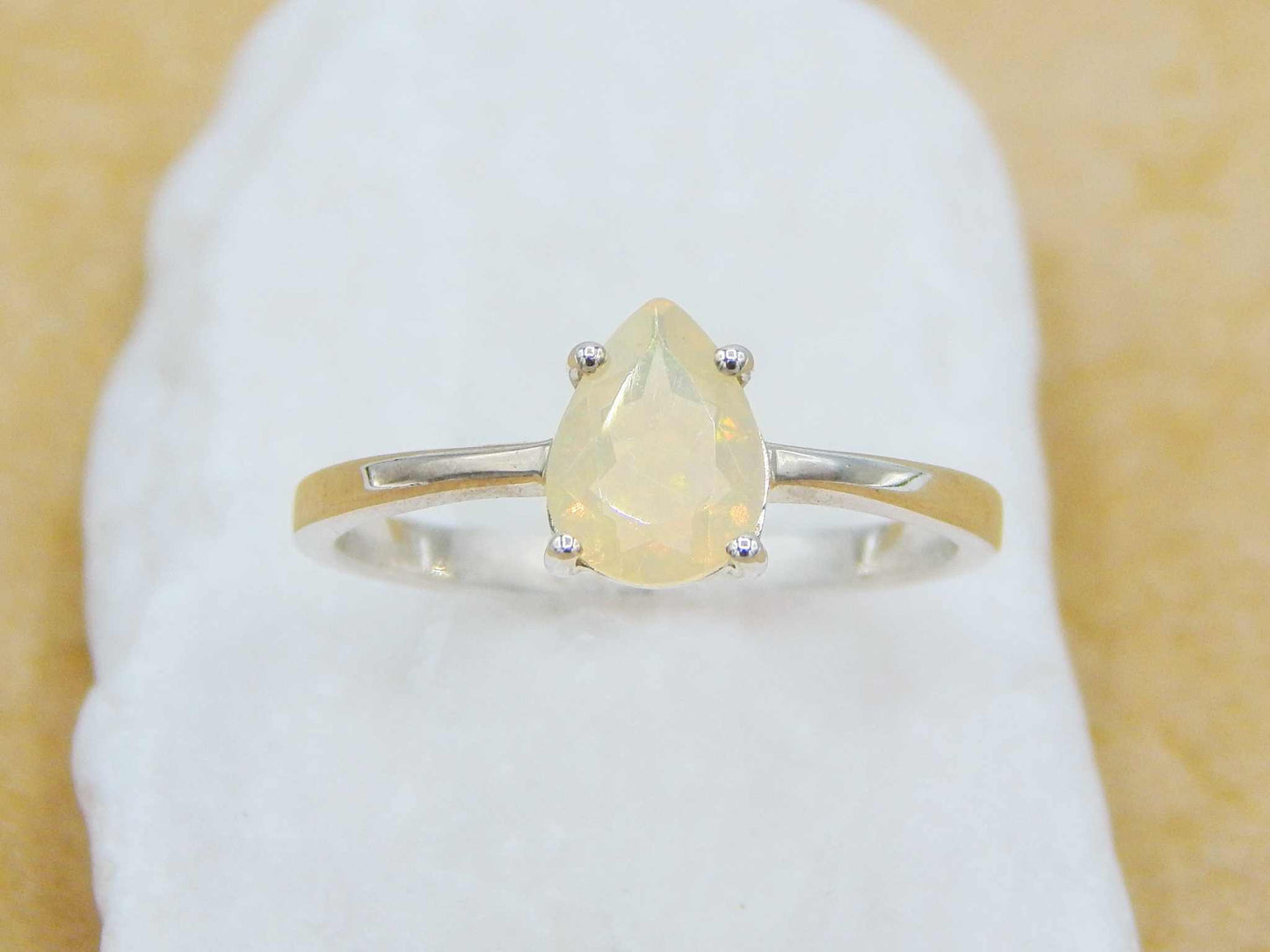 925 Silver Opal Pear Cut Ring showcasing a luminous opal in a 4-prong setting on a sleek 2mm silver band, ideal for stacking or solo wear.