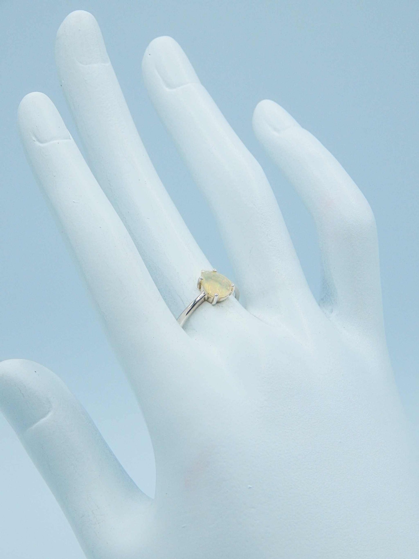 Genuine Opal Pear Cut Ring in 925 Silver displayed on a mannequin hand, highlighting its delicate design and shimmering gemstone.