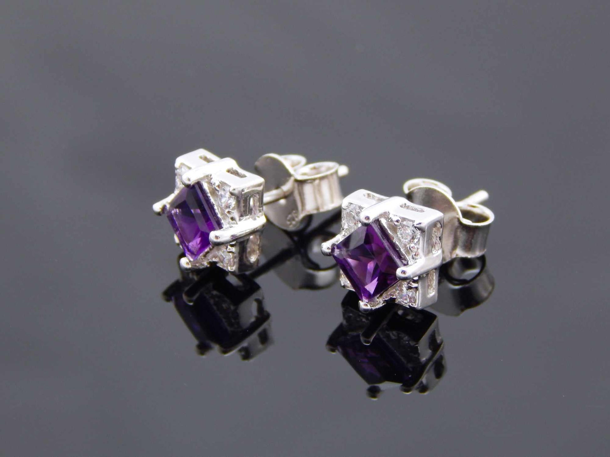 Genuine purple amethyst cushion cut stud earrings in sterling silver with cubic zirconia.