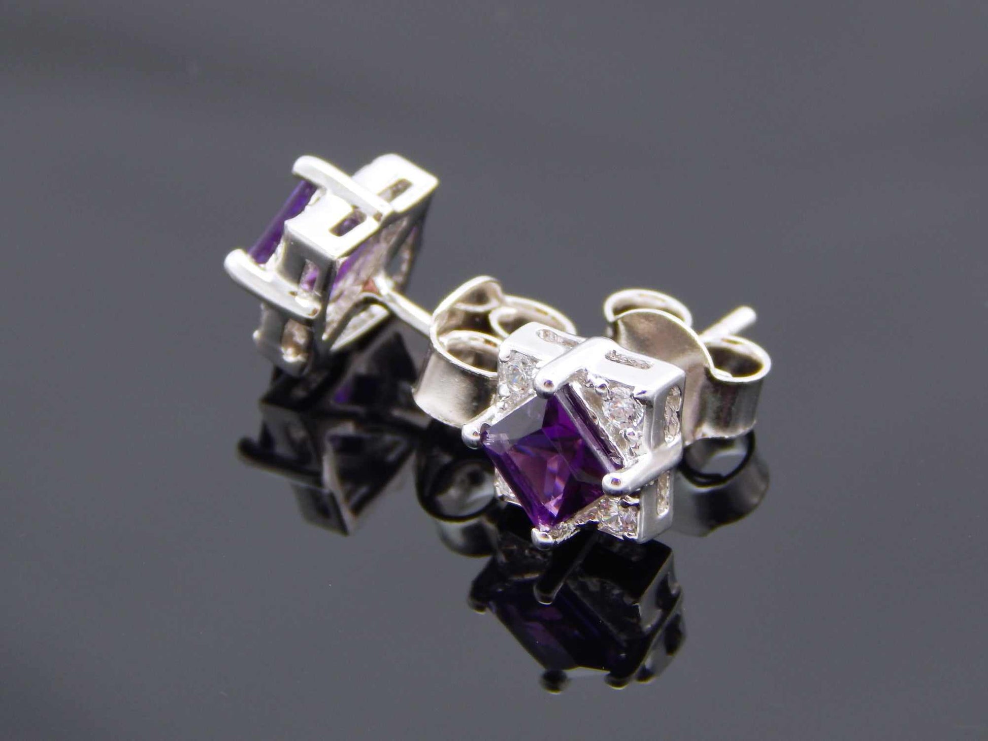 Genuine purple amethyst cushion cut stud earrings in sterling silver with cubic zirconia.